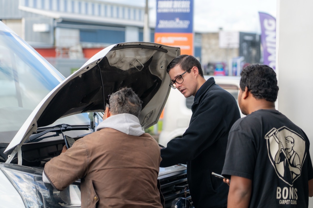 Turbo & Diesel staff member consulting with two customers over an open bonnet.