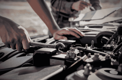 A car mechanic in Hamilton is repairing a vehicle engine with tools