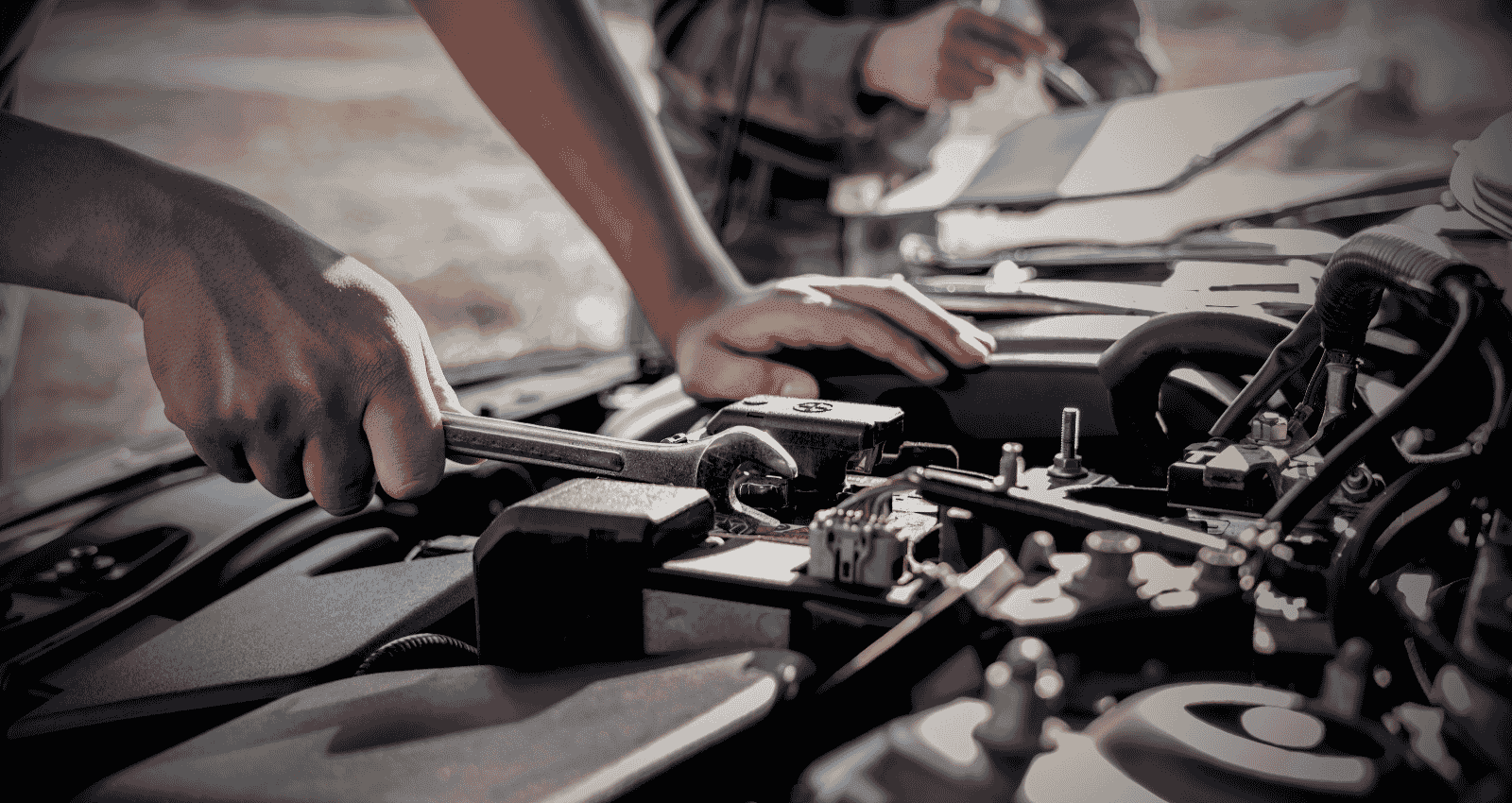 A car mechanic in Hamilton is repairing a vehicle engine with tools